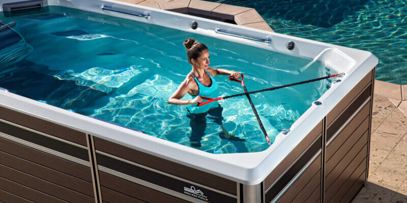 Woman considering buying and using row bars in and comparing swim spas