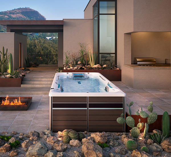 Swim spa installation next to fireplace in backyard